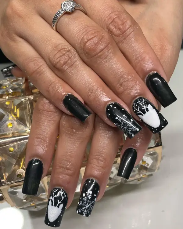 Black nails with a white reindeer design idea for long and short Christmas black and white nails ideas