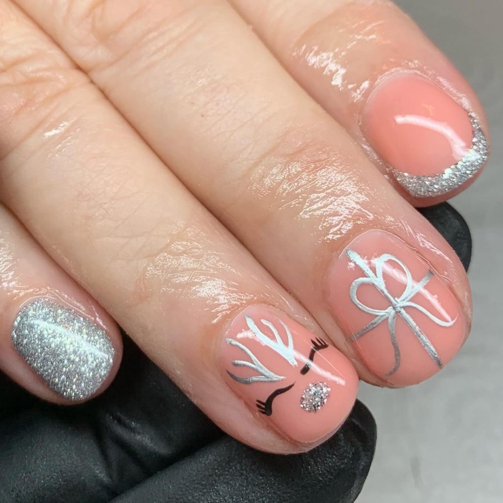 Pink nails with silver reindeer-designed nails and silver glitter nose 