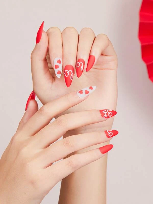 Red and white nails design with heart-shaped patterns Valentines nails design idea